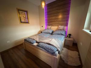 two twin beds in a room with purple lights at Penthouse Happy Seasons in Hajdúszoboszló