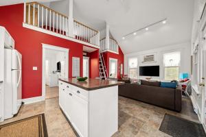a kitchen and living room with red walls and a couch at The Tree Frog - 12 Pine Forest in Cherry Valley