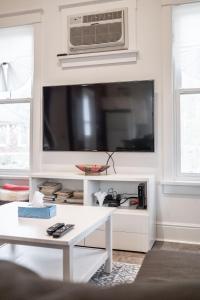 a living room with a tv and a white table at The Tree Frog - 12 Pine Forest in Cherry Valley