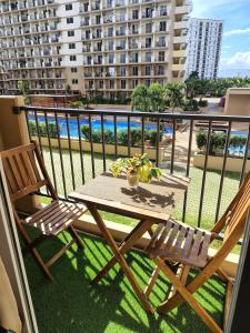 a balcony with a table and two chairs on a balcony at Homey Apartment with Olympic-sized pools in Lapu Lapu City