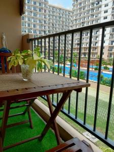 a table on a balcony with a view of a building at Homey Apartment with Olympic-sized pools in Lapu Lapu City