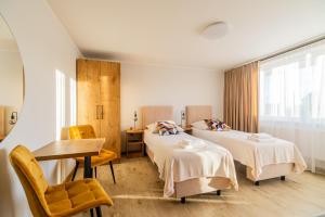 a room with two beds and a table and chairs at FAMILKA in Karwia