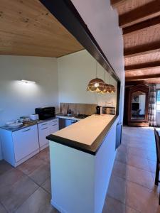 a large kitchen with white cabinets and a counter top at Maison L union in Beauvoir-sur-Mer