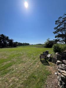 a bench in a field with the sun in the sky at Maison L union in Beauvoir-sur-Mer