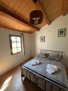 a bedroom with a bed in a room with a ceiling at Maison L union in Beauvoir-sur-Mer