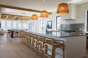 a kitchen with a long bar with stools at Waterfront Luxury Home - Tidelands House in Key West