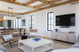 a living room with a tv on a wall at Waterfront Luxury Home - Tidelands House in Key West