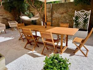 チヴィタノーヴァ・マルケにあるCasa Jouy con giardino a due passi dal mareの木製テーブル(椅子、傘付)