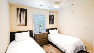 a bedroom with two beds and a window at Watermen's Cabana 2A - 3-Bed, 2-Bath Apartment - Walk To BEACH Access & PET Friendly! in Waves +24 photos