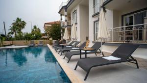 a row of chaise lounge chairs next to a swimming pool at HONEY SUİTEs 1 in Fethiye
