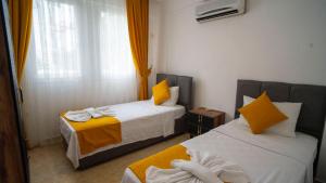 a room with two beds with yellow and white at HONEY SUİTEs 1 in Fethiye