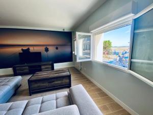 un salon avec un canapé et une grande fenêtre dans l'établissement Les gîtes du pécheur !, au Crotoy