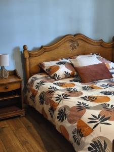 a bed with a comforter and pillows on it at La maison des Bretzels GÎTE Jacuzzi privé illimité in Pfaffenhoffen