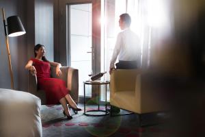 南京市にあるプルマン 南京 禄口空港のホテルの部屋の椅子に座る男女