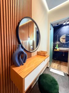 a round mirror on a wooden counter in a bathroom at Luna Mare Boutique Seaside in Borsh