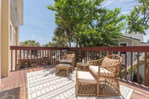 ジャクソンビル・ビーチにあるBe A Nomad - Beach Home Yard & Officeのパティオ(デッキの椅子とテーブル付)