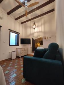 a living room with a blue couch and a television at Home Sweet Casa de los Arcos Parking Free in Córdoba +22 photos