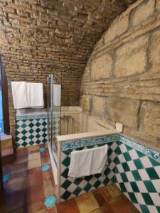 a bathroom with a checkered floor and a bath tub at Home Sweet Casa de los Arcos Parking Free in Córdoba