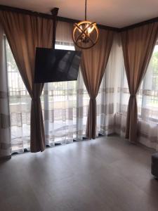 a living room with curtains and a flat screen tv at Апартаменти ''Димови'' in Lozenets