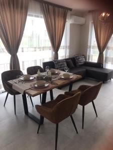 a living room with a table and chairs and a couch at Апартаменти ''Димови'' in Lozenets