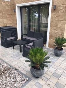 a patio with two chairs and a table and plants at Апартаменти ''Димови'' in Lozenets