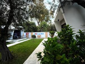 a courtyard of a building with a tree and grass at Luna Mare Boutique Seaside in Borsh