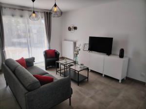 a living room with a couch and a flat screen tv at Sologne Escape in Tour-en-Sologne