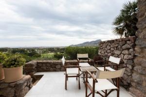 a patio with a table and chairs and a stone wall at Los Miradores Two Bedroom Apartment La Manga Club RPM387 in Atamaría