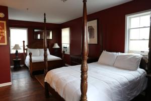 2 letti in una camera da letto con pareti rosse di Tavern on the Bay Hotel - Meyer Lansky Suite a Somers Point