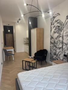 ein Schlafzimmer mit einem Bett und einem Schreibtisch und Stühlen in der Unterkunft Drzewna Apartamenty-Wojska Polskiego in Zielona Góra