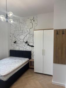 ein Schlafzimmer mit einem Bett und einer Wand mit einer Karte in der Unterkunft Drzewna Apartamenty-Wojska Polskiego in Zielona Góra