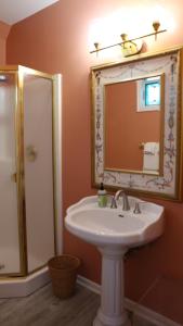 un bagno con lavandino e doccia con specchio di Tavern on the Bay Hotel - Meyer Lansky Suite a Somers Point