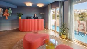 a man is standing at a desk in a room with at Hotel Indigo Albufeira by IHG in Albufeira
