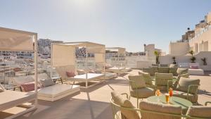 a patio with chairs and tables on a roof at Hotel Indigo Albufeira by IHG in Albufeira