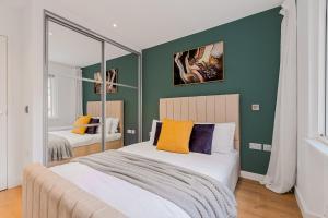 Un dormitorio con dos camas y una pared verde. en 2 BD Soho Luxury Living-High Ceilings Huge Terrace, en Londres