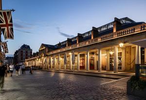 una calle adoquinada con gente caminando delante de un edificio en 2 BD Soho Luxury Living-High Ceilings Huge Terrace, en Londres