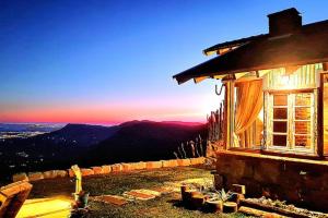 a building with a sunset in the background at Porta Garibaldi - Pousada e Cabanas in Igrejinha