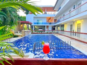 a swimming pool with a red drink in the middle at Awa De Mar Hotel Tolu in Tolú