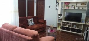 a living room with a couch and a television at Casa do Aconchego in Rio Forcação