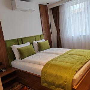 a bedroom with a large bed with a green headboard at Mandrina 10 Free Parking in Sarajevo