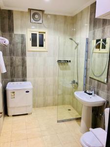 a bathroom with a shower and a toilet and a sink at تولين بارك in Taif