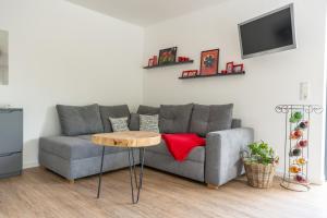 a living room with a gray couch and a table at Ferienhaus "Casa Lotti" in Sangerhausen