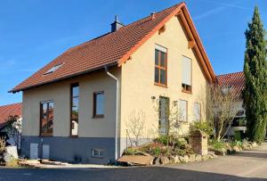 ein Haus mit einem Kreuz darüber in der Unterkunft Ferienhaus am Waldrand Village Holiday home in Bobenheim am Berg
