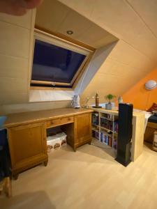 Zimmer im Dachgeschoss mit einem Schreibtisch und einem Fenster in der Unterkunft Ferienhaus am Waldrand Village Holiday home in Bobenheim am Berg