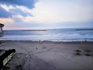 a beach with some chairs and umbrellas and the ocean at Ras El Bar Apartments in Ras El Bar