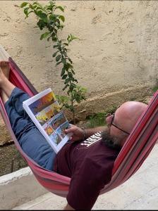 a man laying in a hammock reading a book at Hostel le Rhumel in Constantine +21 photos