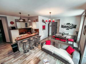a living room with a couch and a kitchen with a table at Le Cosy in Gérardmer