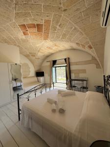a bedroom with a large white bed with a stone ceiling at Dimora 69 in Lecce