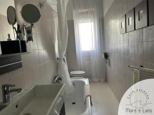 ein weißes Badezimmer mit Waschbecken und Toilette in der Unterkunft Casa vacanze - Mare e Luna in Montesilvano + 19 Fotos