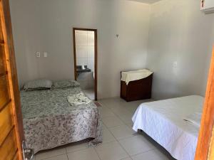 ein kleines Schlafzimmer mit zwei Betten und ein Badezimmer in der Unterkunft Casa beira-mar - Luis Correia in Luis Correia